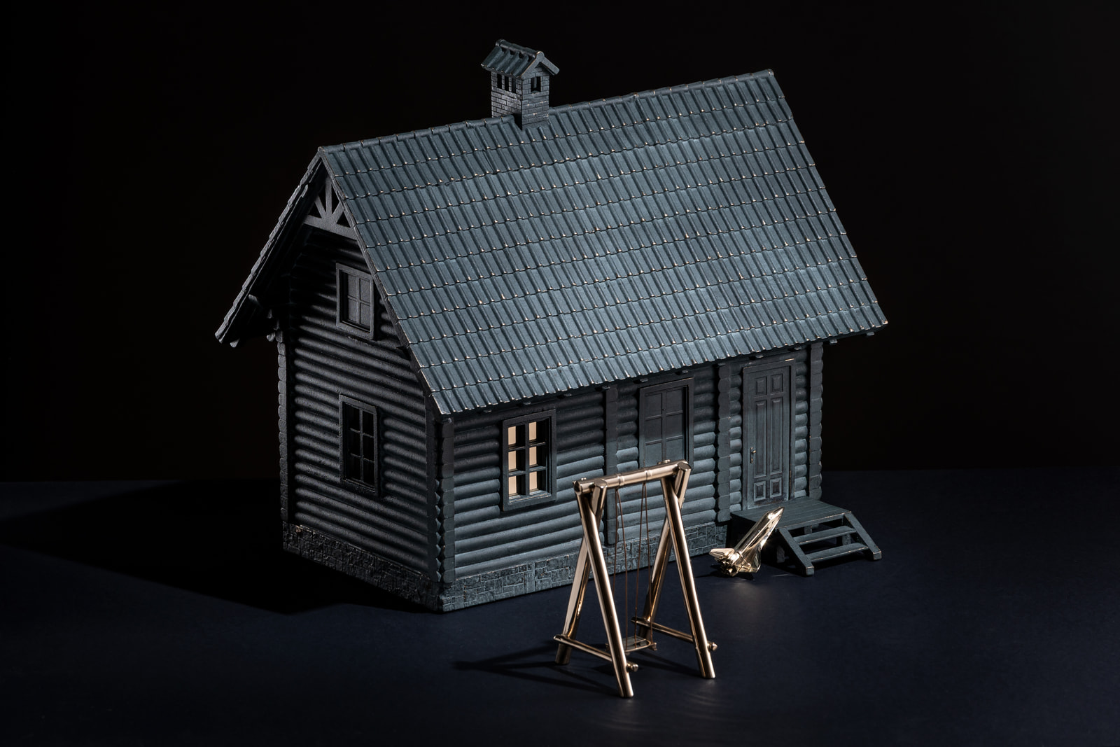 Dim — bronze sculpture by Max Sheika, 2026: a log house with a swing and a shuttle
