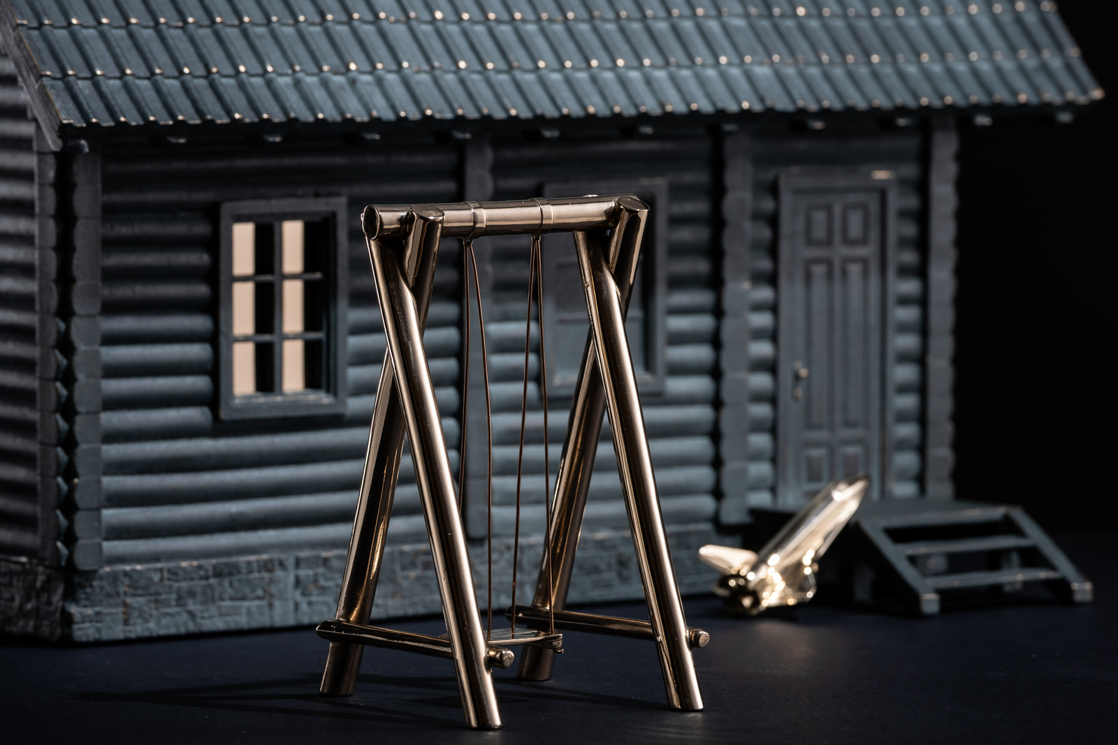Dim — detail, the polished bronze swing in front of the house