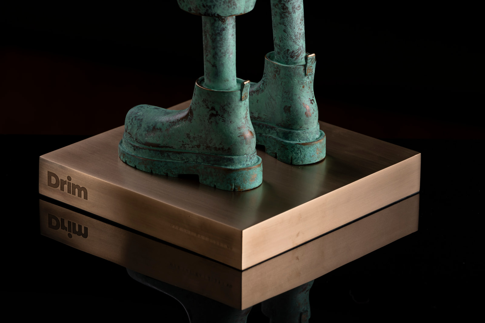 Drim — boots on the engraved plinth