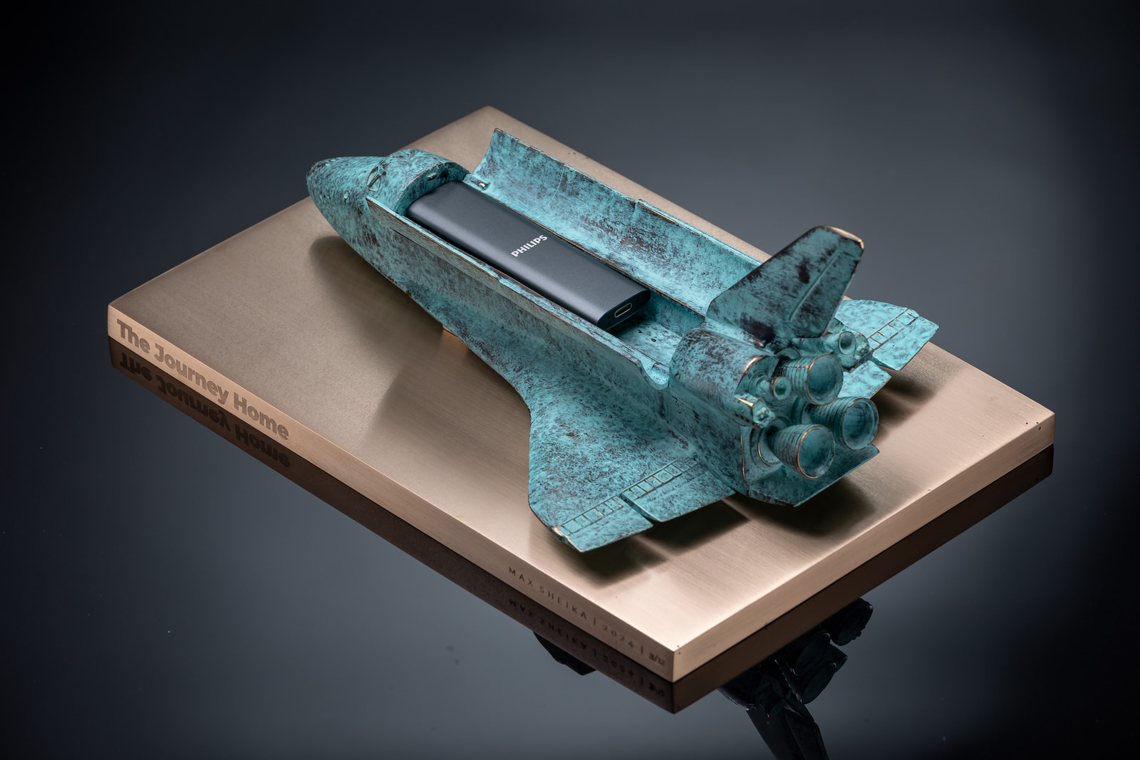 The bronze shuttle containing the film's SSD — the physical carrier of The Journey Home