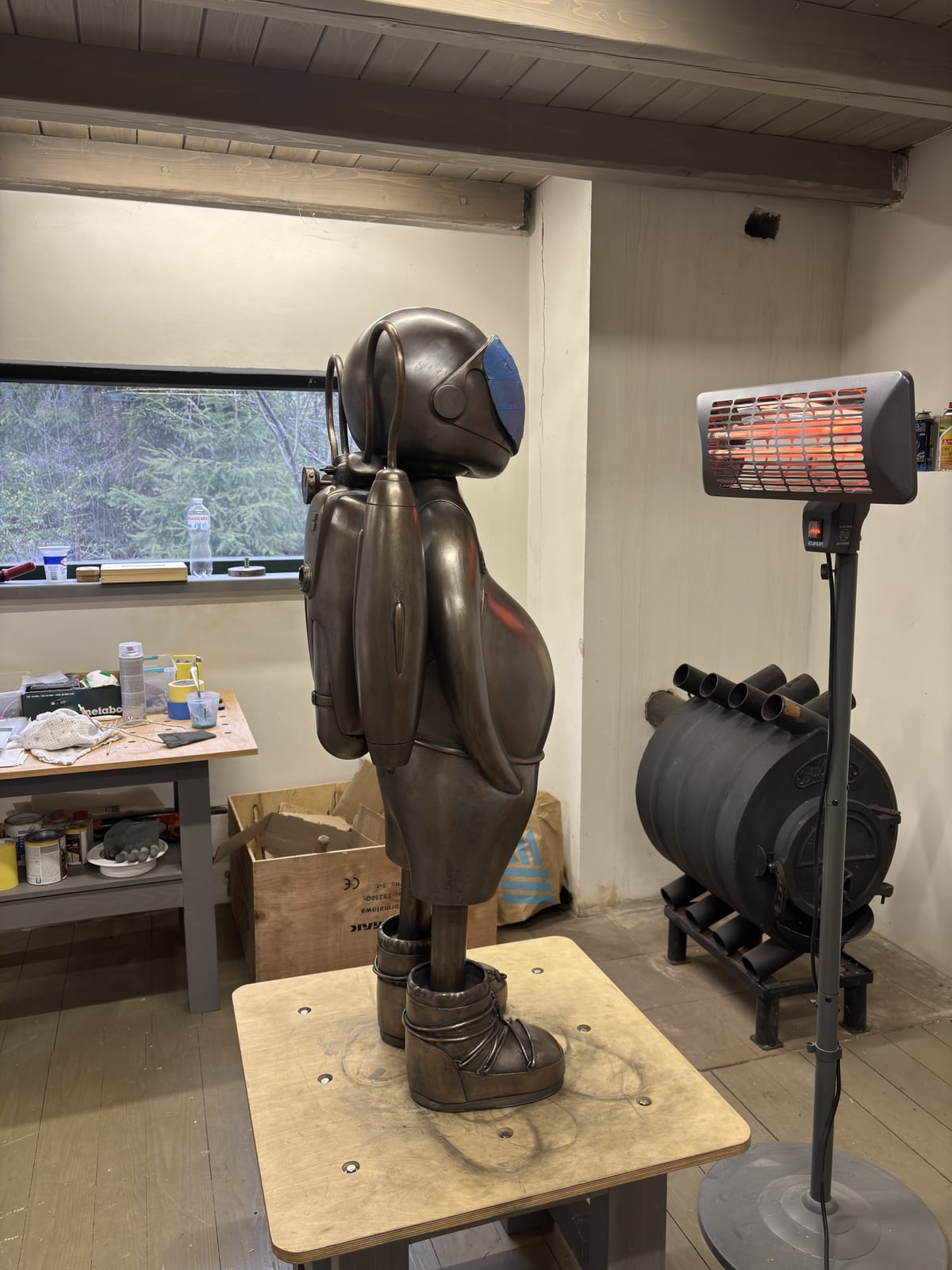 A figure in profile on the worktable during patination