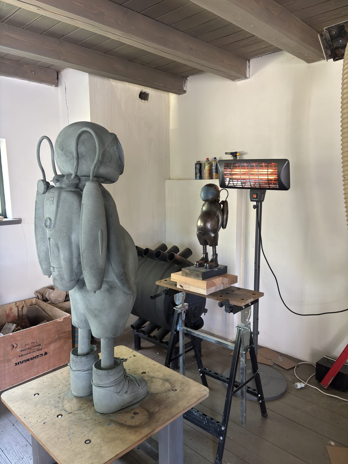 A figure at the wax stage, under the heat lamp